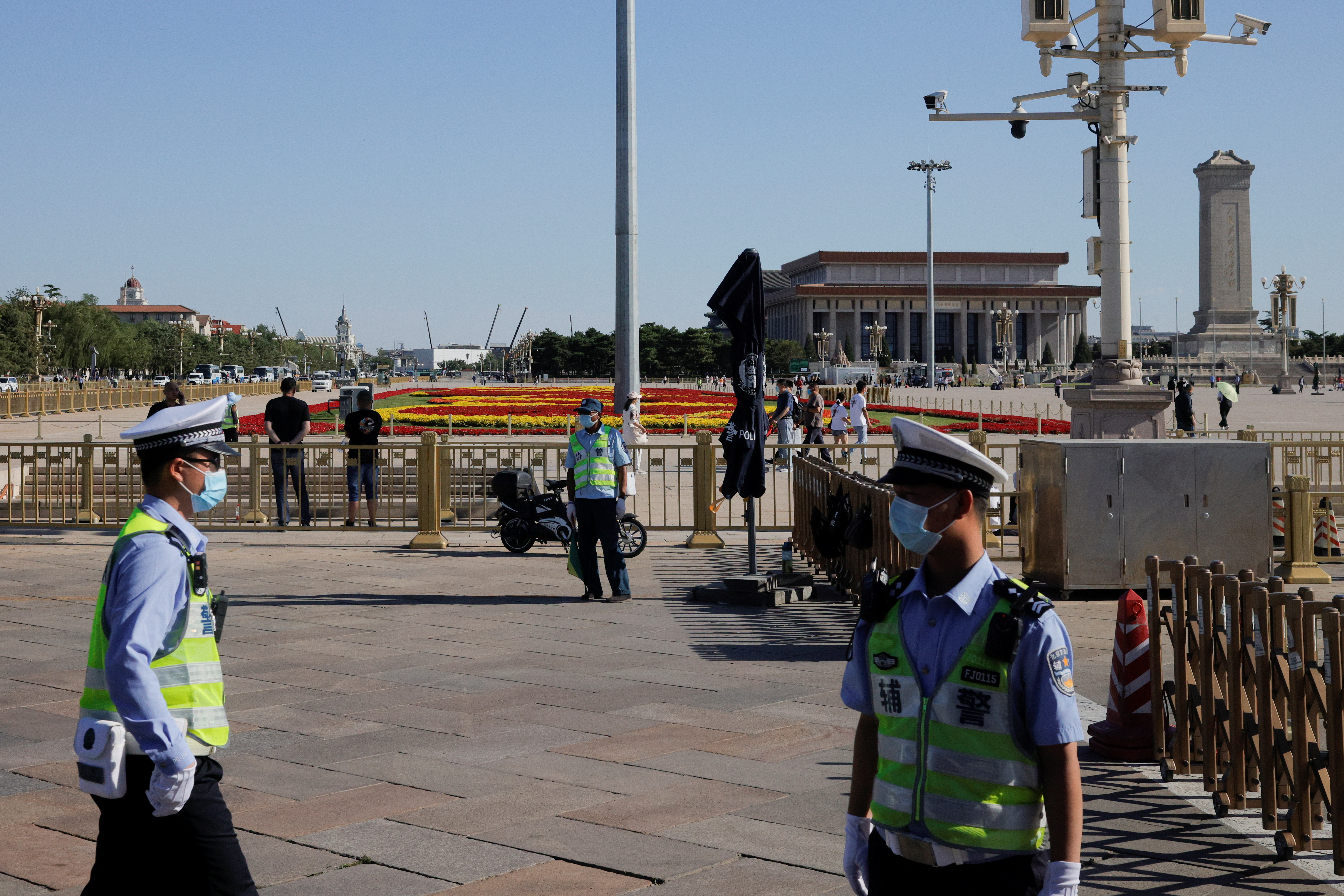 Police officers patrol in Tiananmen Square in Beijing, China, June 3, 2021. Picture shot through a window.  REUTERS/Thomas Peter