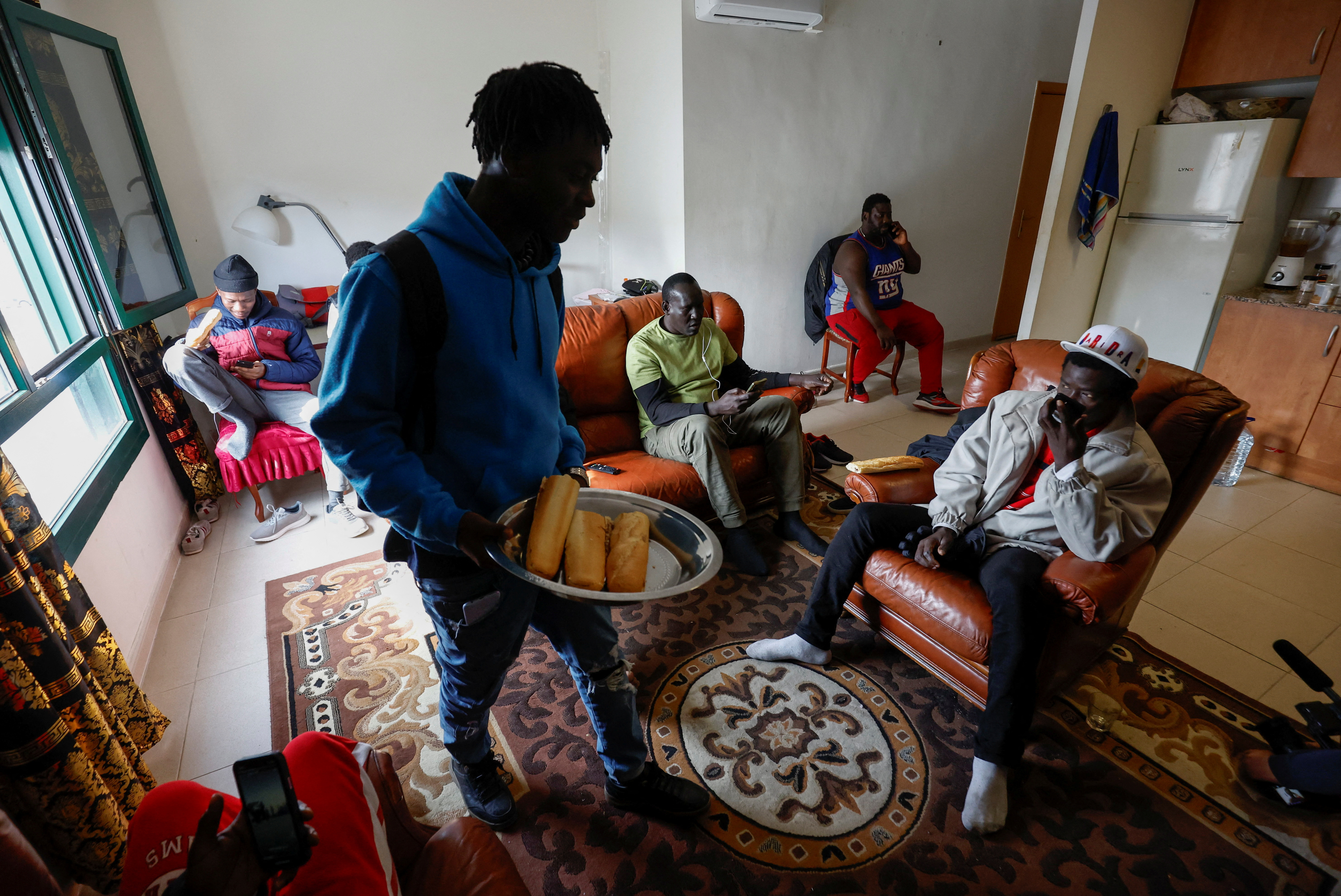 Senegal former fisherman Khalifa Ndou sits to have a drink at Papa Sidi Ngom's apartment in Guissona town