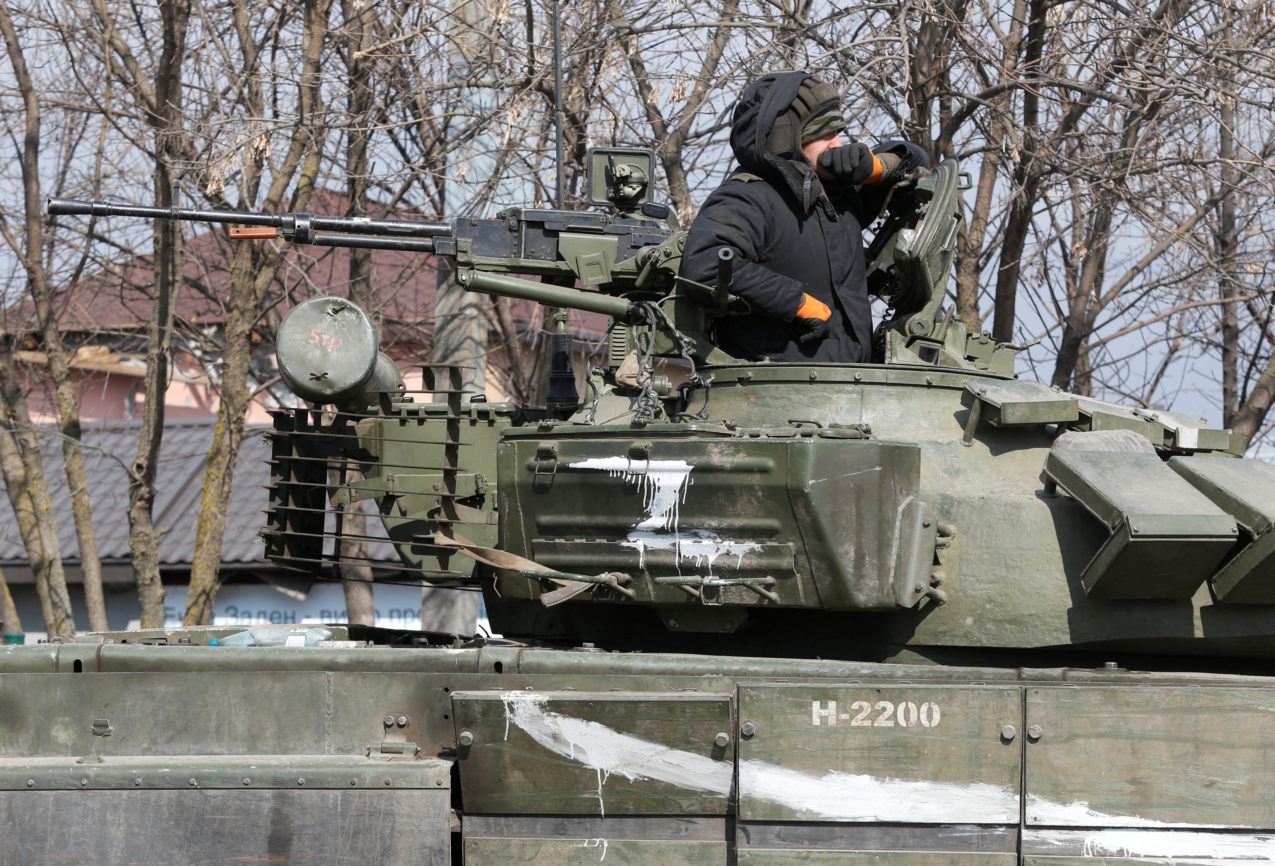 A service member of pro-Russian troops is seen atop of a tank in the besieged city of Mariupol