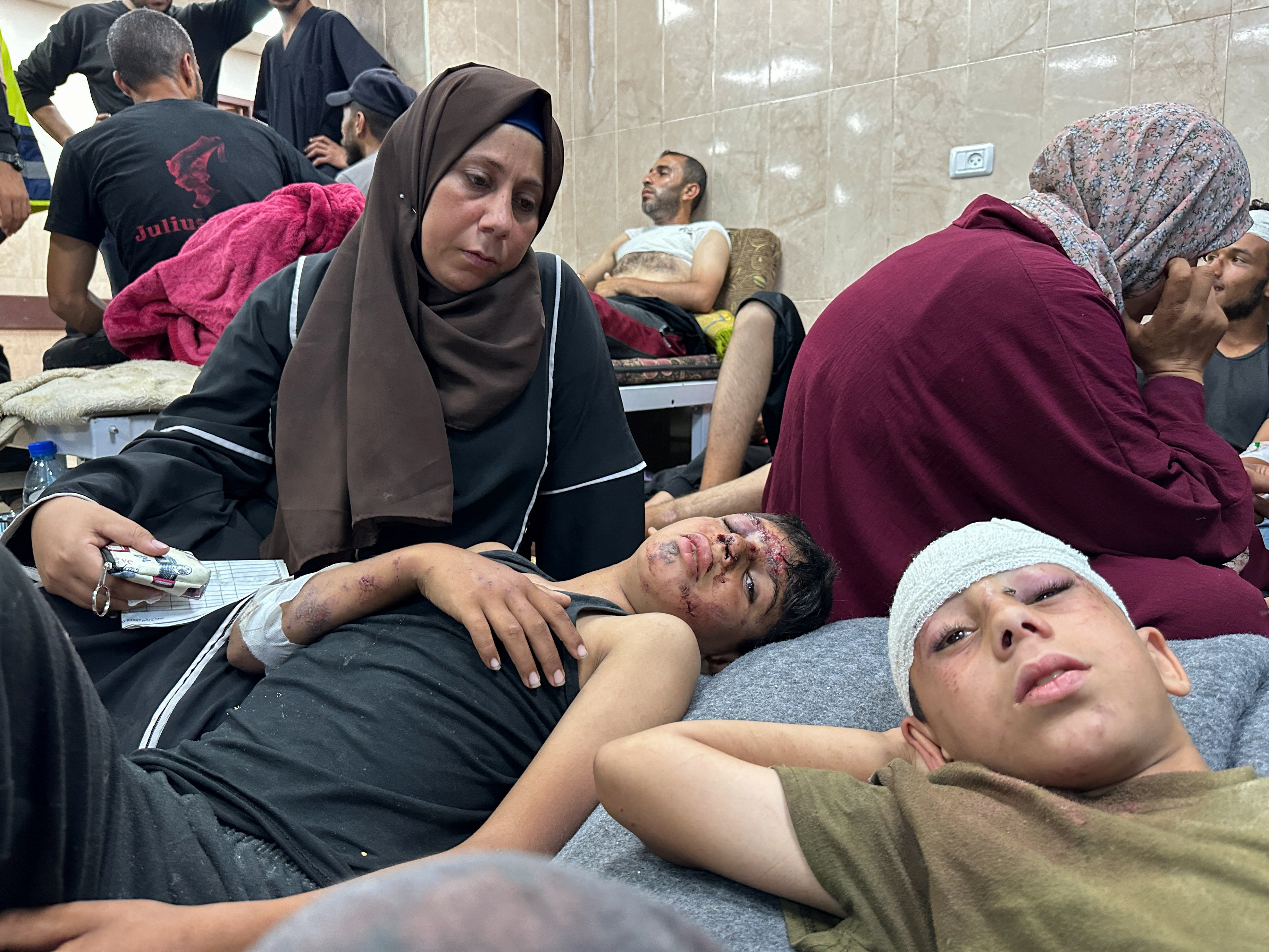 Wounded Palestinians injured in an Israeli strike on a UNRWA school at Al-Aqsa Martyrs Hospital