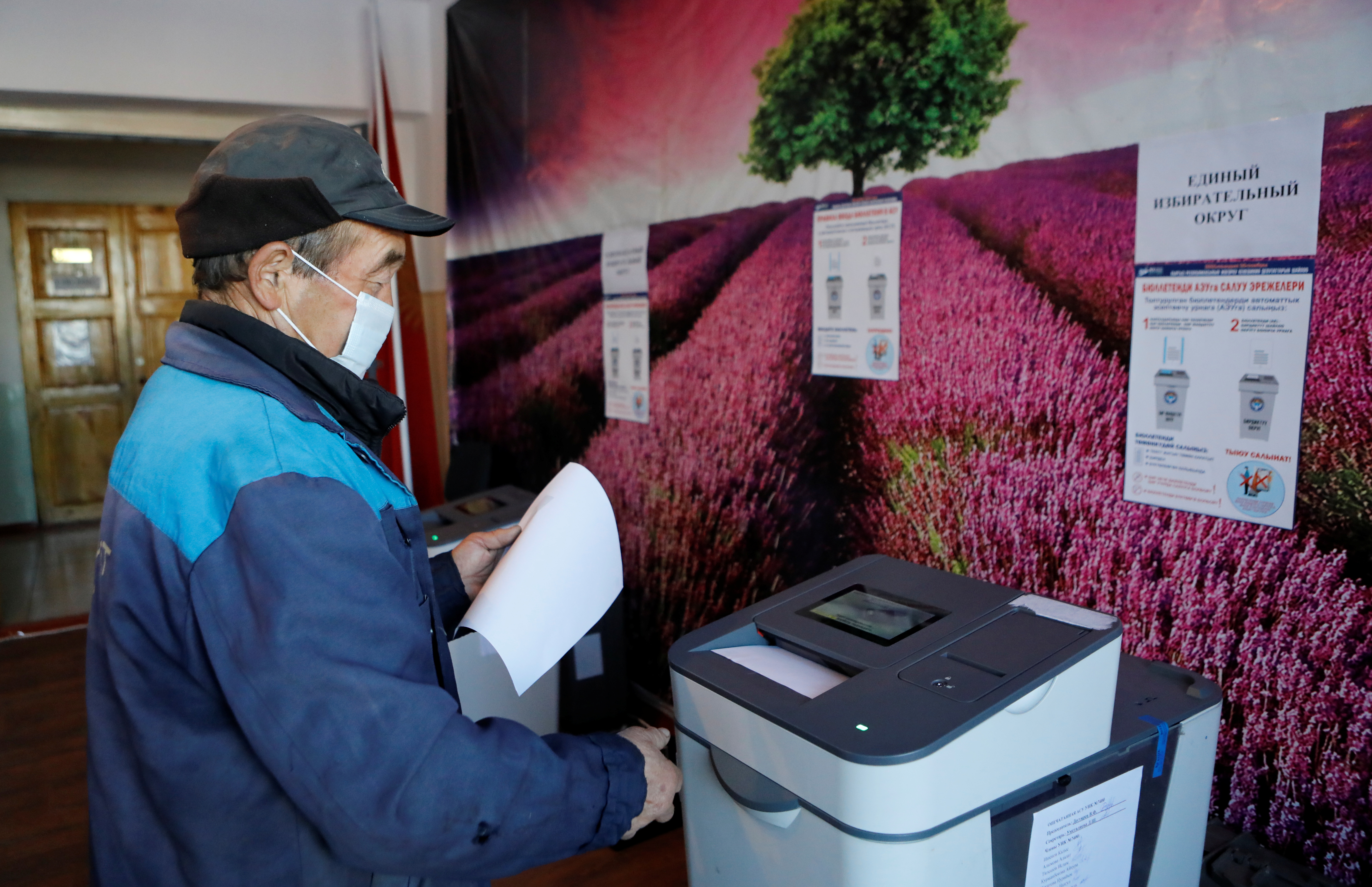 A man casts his ballots at a polling station during the parliamentary election in the settlement of Arashan outside Bishkek, Kyrgyzstan, November 28, 2021. REUTERS/Vladimir Pirogov