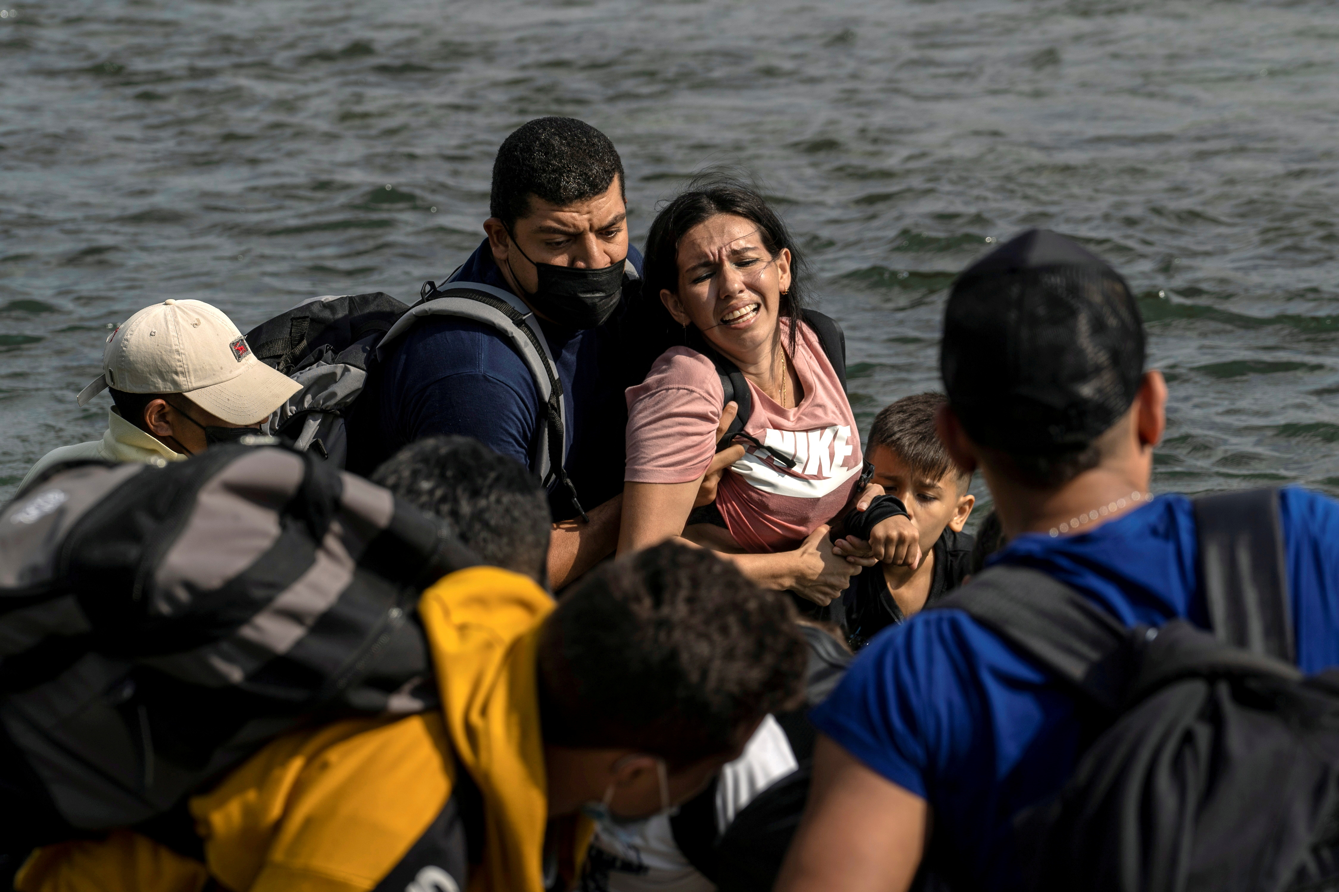An asylum-seeking migrant woman from Venezuela reacts as she walks in the water to cross the Rio Grande river into the United States from Mexico in Del Rio, Texas, U.S., May 26, 2021. REUTERS/Go Nakamura/File Photo