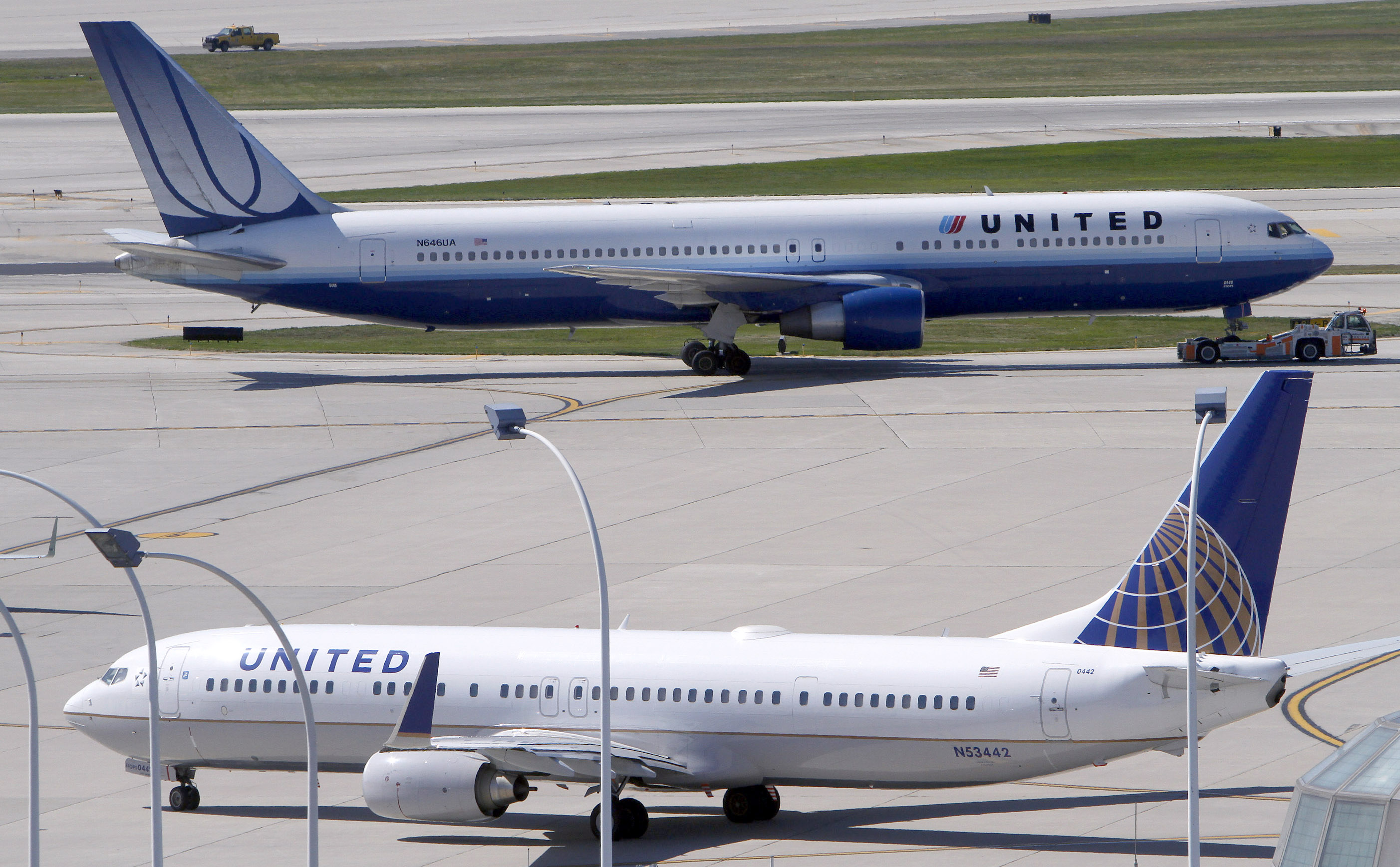 A United Airlines plane with the Continental Airlines logo on its tail, taxis to the runway while another United plane heads for the gate at O'Hare International airport in Chicago