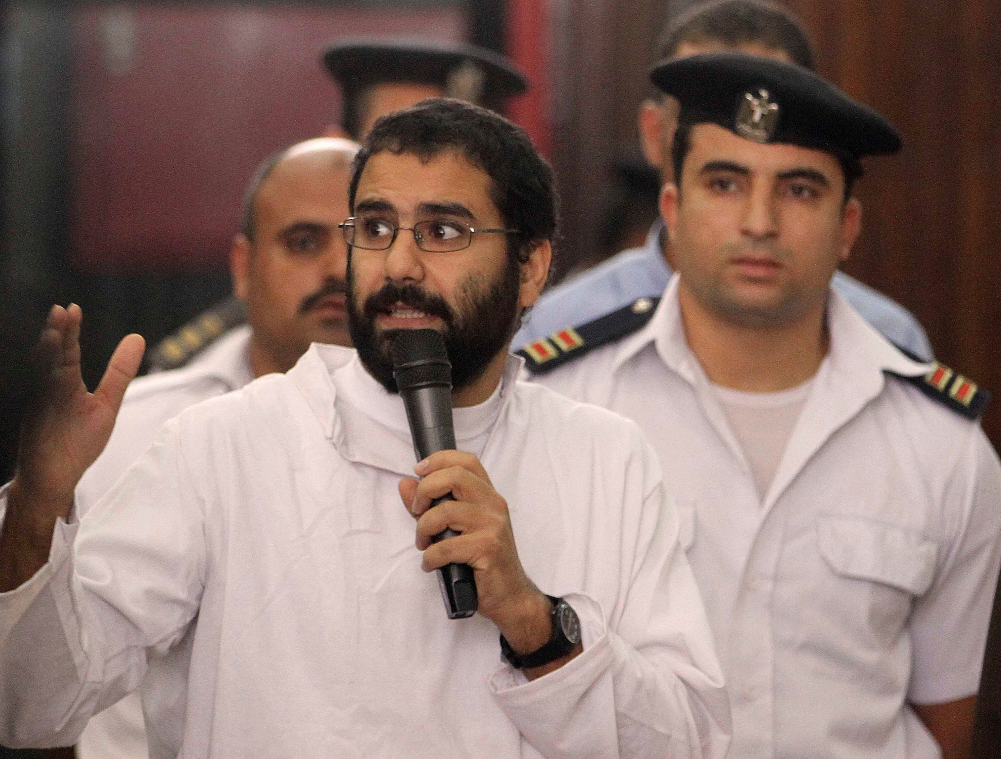 Activist Alaa Abd el-Fattah speaks in front of a judge at a court during his trial in Cairo